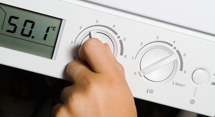 Personne réglant le thermostat d'une chaudière