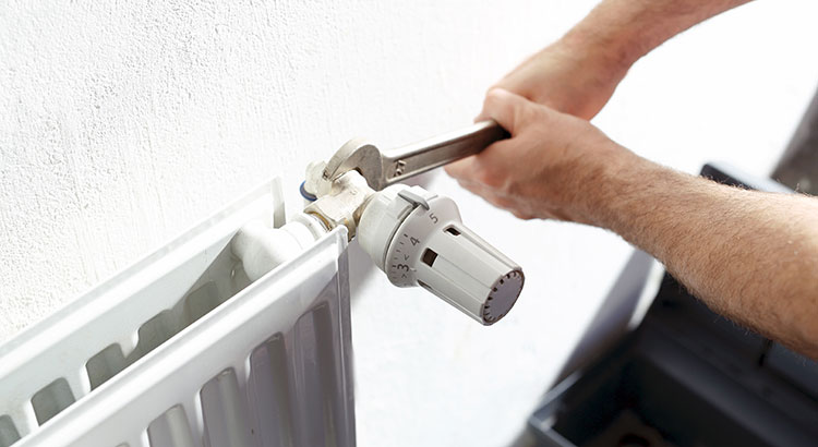 Réparation d'un radiateur mural avec clé de serrage