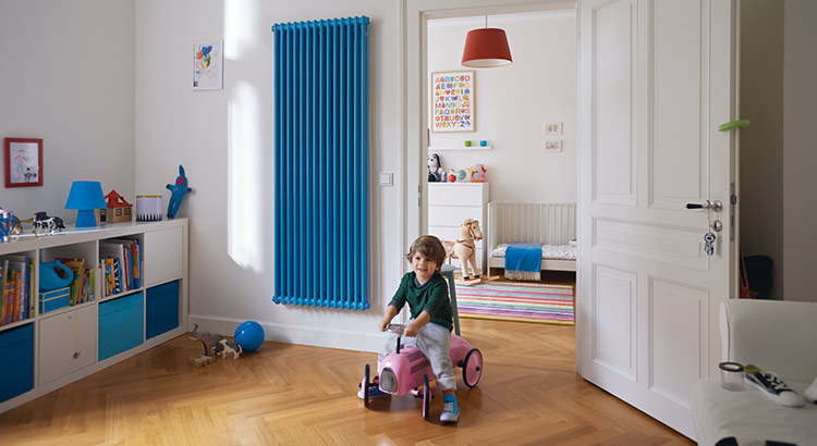 Enfant jouant dans une chambre avec radiateur mural bleu en arrière-plan
