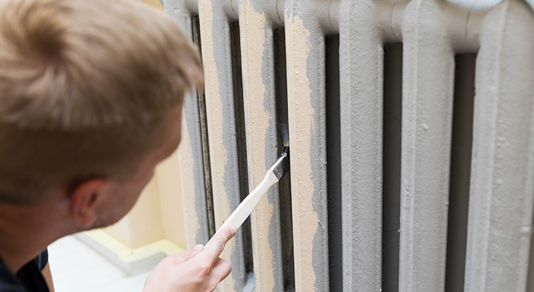 Personne peignant un radiateur