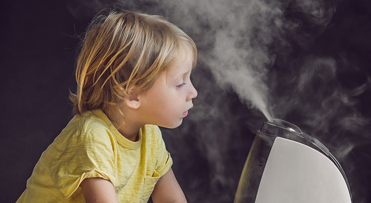 Enfant appréciant la brume d'un humidificateur