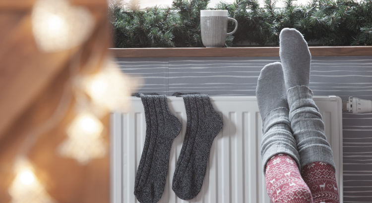 Femme se réchauffant les pieds sur un chauffage
