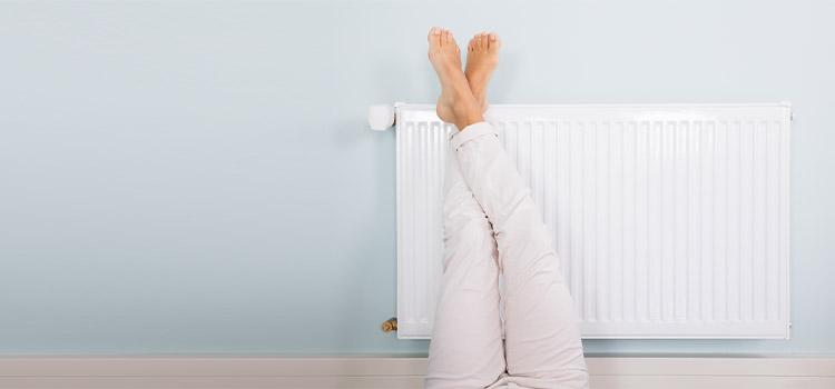 les pieds d'une femme poser sur un radiateur