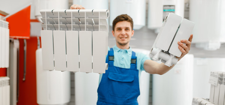 Chauffagiste présentant des composants de radiateur