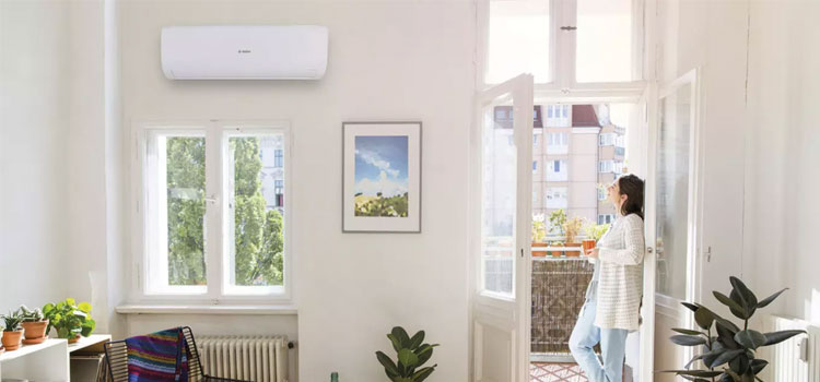 Jeune femme admirant son unité de climatisation murale