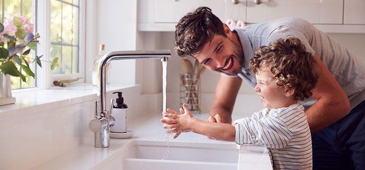 papa qui aide son fils à se laver les mains
