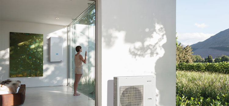 Jeune femme contemplant la nature depuis la baie vitrée de sa chambre