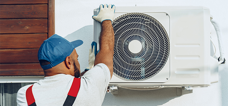 Professionnel installant un groupe extérieur de climatisation