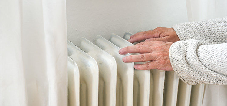 Personne posant ses mains sur un radiateur