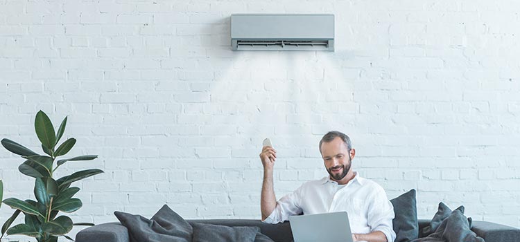 homme qui profite de sa climatisation dans le salon